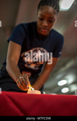 Arabischen Golf (24. April 2017) der Maschinist Mate 3. Klasse Khiarea Deshazer leuchtet eine Kerze bei der Erinnerung an den Holocaust Zeremonie an Bord der Flugzeugträger USS George H.W. gehalten Bush (CVN 77) (GHWB). GHWB ist in den USA der 5. Flotte Bereich für Maßnahmen zur Erhöhung der Sicherheit des Seeverkehrs auf die Verbündeten und Partnern zu beruhigen bereitgestellt, und der Freiheit der Schiffahrt und des freien Handels in der Region erhalten. Stockfoto