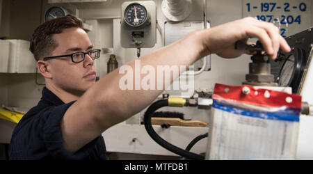 Arabischen Golf (24. April 2017) Aviation strukturellen Mechaniker Airman Kevyn Lucas regelt den Luftdruck eines Reifens an Bord der Flugzeugträger USS George H.W. Bush (CVN 77) (GHWB). GHWB ist in den USA der 5. Flotte Bereich für Maßnahmen zur Erhöhung der Sicherheit des Seeverkehrs auf die Verbündeten und Partnern zu beruhigen bereitgestellt, und der Freiheit der Schiffahrt und des freien Handels in der Region erhalten. Stockfoto