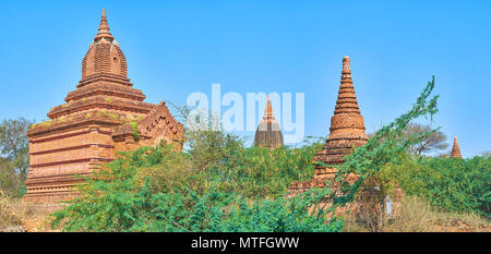 Die Gruppe der kleinen Tempel und Stupas mit üppigem Grün in den archäologischen Park von Bagan, Myanmar umgeben Stockfoto