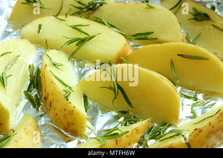 Rohe Kartoffel Wedges mit Rosmarin auf Folie Backblech abgedeckt Stockfoto