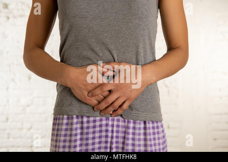Nahaufnahme von einer jungen Frau, schmerzliche Magenschmerzen, Hände auf ihren Bauch. Körper Schmerzen, Gastritis, Verstopfung, Schmerzen und Krämpfe. Stockfoto