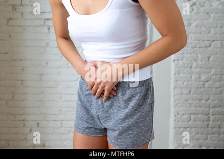 Nahaufnahme von einer jungen Frau, schmerzliche Magenschmerzen, Hände auf ihren Bauch. Körper Schmerzen, Gastritis, Verstopfung, Schmerzen und Krämpfe. Stockfoto