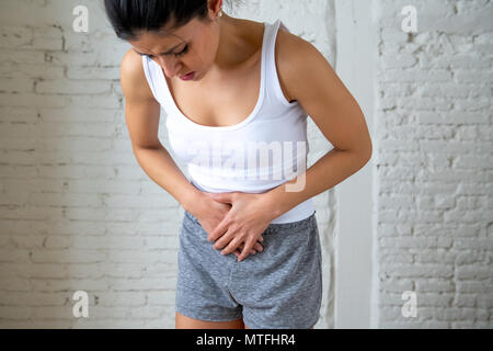 Nahaufnahme von einer jungen Frau, schmerzliche Magenschmerzen, Hände auf ihren Bauch. Körper Schmerzen, Gastritis, Verstopfung, Schmerzen und Krämpfe. Stockfoto