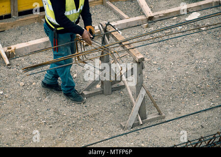 Arbeiter Hände, Verstärkung aus Metall Rahmen für Beton gießt auf der Baustelle. Stahl Riegel arbeiten. Stockfoto