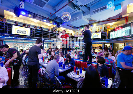 Kellner performing Songs aus Musicals in Ellens Stardust Diner Restaurant, während Diners auf, Broadway, New York City, USA Stockfoto