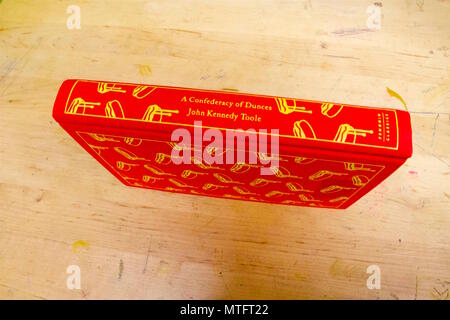 Eine Konföderation der Hohlköpfe, rot Hardcover Form zur Festlegung auf die Seite auf einem Schreibtisch, ist ein schelmenroman von amerikanischen Romancier John Kennedy Toole Stockfoto