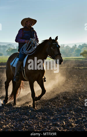 Eine mexikanische COWBOY galoppiert in Dämmert früh Licht - San Miguel de Allende, Mexiko Stockfoto