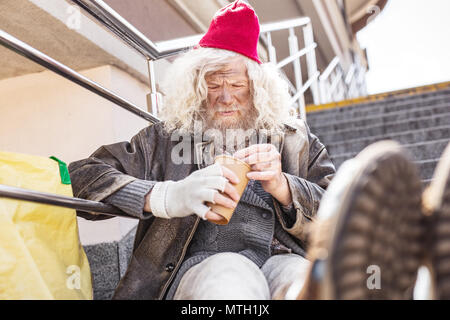 Unglückliche arme Mann Zählen von Münzen Stockfoto