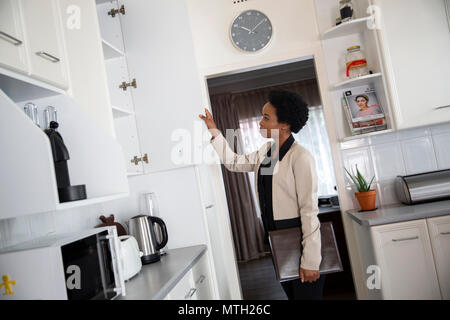 Immobilienmakler in Kitchen cabinet suchen Stockfoto