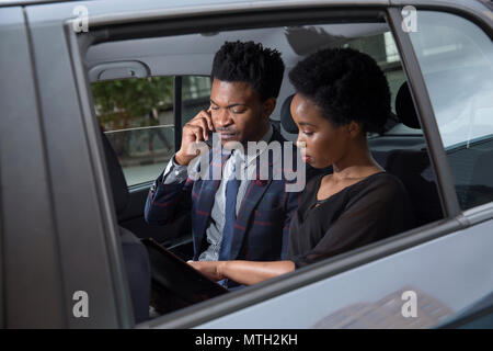 Der Mann und die Frau auf dem Rücksitz des Autos sitzen Stockfoto