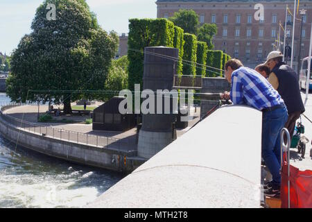 Urban Fischer oder angler angeln in den Riksbron Brücke in Stockholm, wo das frische Wasser des Sees Malaren der Ostsee erfüllen Stockfoto