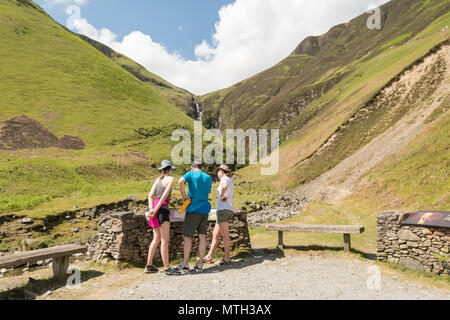 Grau Mares Schwanz Nature Reserve, Dumfries und Galloway, Schottland, UK-Wanderer lesen Information Board vor Grauen Stuten Schwanz Wasserfall Stockfoto