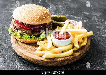 Beef Burger mit Salat und Tomate, Kartoffel, Pommes und Ketchup. Fast Food Stockfoto