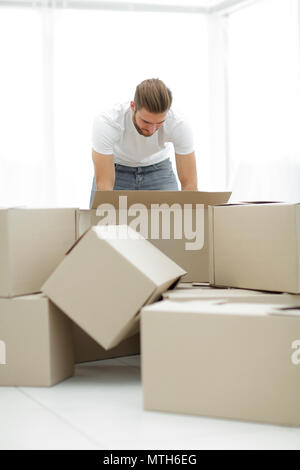 Männliche Sortierung Sachen in die neue Wohnung. Stockfoto