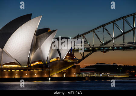 Sydney Opera House und die Harbour Bridge bei Nacht als Harbour Fähre vorbei. Kletterer auf die Sydney Harbour Bridge sind deutlich sichtbar. Stockfoto