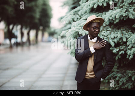 Junge schöne afrikanische amerikanische Geschäftsmann mit Hut zu Fuß auf der Straße Stockfoto