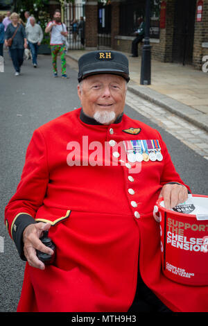 Ein Chelsea Rentner in seiner Uniform gekleidet und halten eine Sammlung Schaufel auf der Chelsea Flower Show in London, UK. Stockfoto