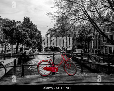 Rotes Fahrrad standin auf einer Brücke, schwarze und weiße Amsterdam Stockfoto