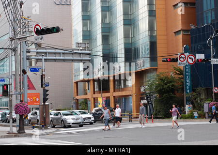 Fußgänger überqueren Sie die Straße über den Zebrastreifen in der Innenstadt von Busan City street. Stockfoto