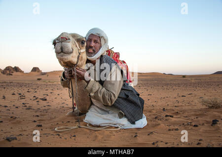 Meroe Pyramiden, Sudan - 19. Dezember 2015: ein Mann mit seinem Kamel in der Wüste Stockfoto