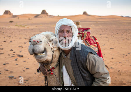 Meroe Pyramiden, Sudan - 19. Dezember 2015: ein Mann mit seinem Kamel in der Wüste Stockfoto