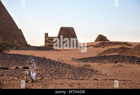 Meroe Pyramiden, Sudan - 19. Dezember 2015: ein Mann mit seinem Kamel in der Wüste Stockfoto