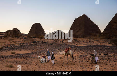 Meroe Pyramiden, Sudan - 19. Dezember 2015: ein Mann mit seinem Kamel in der Wüste Stockfoto