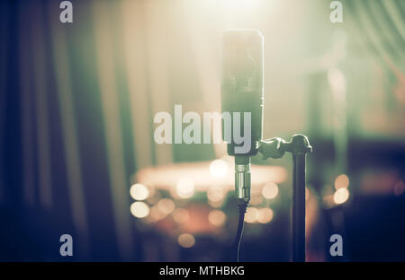 Mikrofon im Studio oder der Konzerthalle close-up, mit Trommel auf den Hintergrund unscharf eingestellt. Schönen unscharfen Hintergrund der bunten Laternen. M Stockfoto