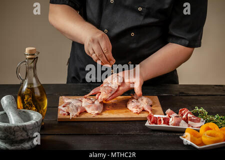 Der Küchenchef bereitet raw Wachtel Schlachtkörper in der Küche. Frisches rohes Fleisch Wachteln bereit für das Kochen auf dem Holzbrett Stockfoto