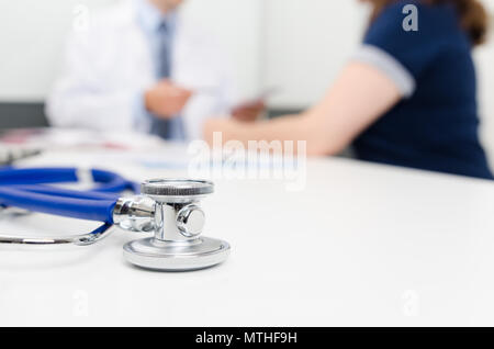 Stethoskop hautnah. Patient und Arzt im Büro. Arzt verordnet das Rezept im Hintergrund Stockfoto