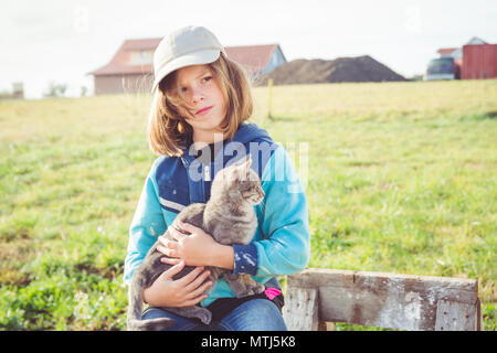 Mädchen/Tween holding Katze (grau tabby Kitten) schützend auf den Aufbau Baustelle zwar tief in Gedanken Stockfoto