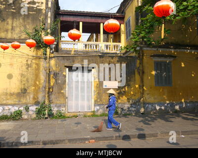 HOI AN, VIETNAM - 20. MÄRZ 2018: Kehrmaschine Arbeiter mit Besen Reinigung der Straße im Zentrum der Weltkulturerbe Stadt Hoi An Stockfoto