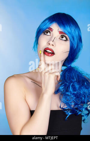 Porträt der jungen Frau in den komischen Pop art Make-up Stil. Frau in Blau Perücke auf blauem Hintergrund Stockfoto