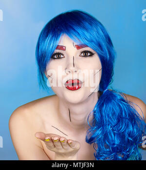 Porträt der jungen Frau in den komischen Pop art Make-up Stil. Frau in Blau Perücke auf blauem Hintergrund. Das Mädchen sendet einen Kuss Stockfoto