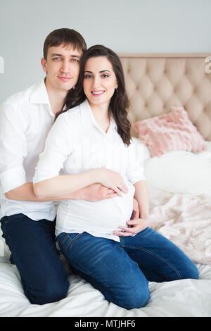 Portrait der schwangeren Frau und ein junger Mann zusammen im Innenbereich Stockfoto