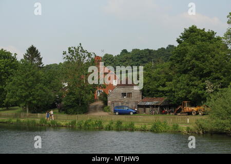 Lifestyle - Paar neben Anwesen am Wasser auf der Themse bei Henley-on-Thames, Oxfordshire, Großbritannien. Stockfoto