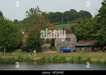 Lifestyle - Paar neben Anwesen am Wasser auf der Themse bei Henley-on-Thames, Oxfordshire, Großbritannien. Stockfoto