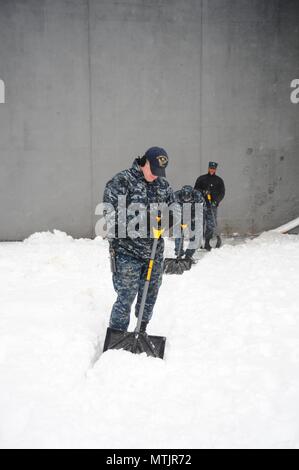 Der Luftfahrt Bootsmann Mate (Start und Wiederherstellung) Airman Zachery Pavey schaufeln Schnee an Bord der Flugzeugträger USS George Washington (CVN 73) im Winter Storm Helena. Das Schiff ist in Norfolk homeported Vorbereitung nach Newport News, Virginia für die Betankung komplex (RCOH) Wartung zu bewegen. (U.S. Marine Foto von Chief Mass Communication Specialist Maria Popejoy/freigegeben) Stockfoto