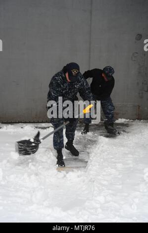 Der Luftfahrt Bootsmann Mate (Start und Wiederherstellung) Airman Zachery Pavey schaufeln Schnee an Bord der Flugzeugträger USS George Washington (CVN 73) im Winter Storm Helena. Das Schiff ist in Norfolk homeported Vorbereitung nach Newport News, Virginia für die Betankung komplex (RCOH) Wartung zu bewegen. (U.S. Marine Foto von Chief Mass Communication Specialist Maria Popejoy/freigegeben) Stockfoto