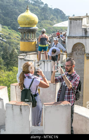 Mann und Frau sind die Bilder von Pena Palast mit ihren Smartphones. Sintra, Portugal. Stockfoto