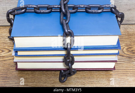 Alte Bücher mit Kette und Schloss auf dem Holztisch Stockfoto