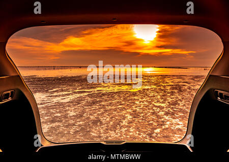 Schöne Meerblick von innen Kofferraum. Meerblick mit orangefarbenen Himmel und Wolken bei Sonnenuntergang am Strand. Freiheit Sommer Reisen mit Reise auf Vac Stockfoto
