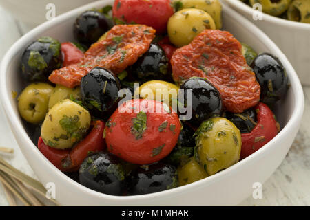 Schüssel mit grünen und schwarzen Oliven, Paprika und Tomaten als Snack Nahaufnahme Stockfoto