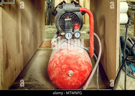 Alte rote Gasflasche mit Meter für das Schweißen von Industriellen in der Werkstatt verwendet Stockfoto
