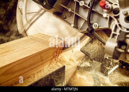 Nahaufnahme von einem erfahrenen Tischler mit Kreissäge zum Schneiden von Holz. Stockfoto