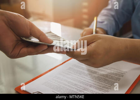 Mann mit Batch von Hundert-euro-Scheine. In der Nähe von Mann unterzeichnen Vertrag machen einen Deal, business Vertragsdaten. Stockfoto