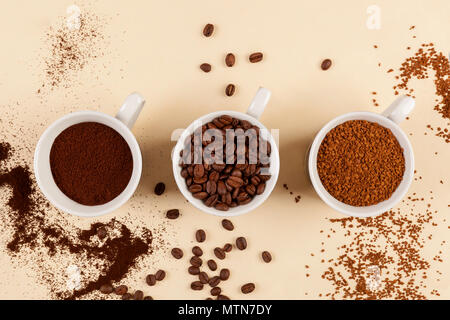 Verschiedene Arten von Kaffee, Instant und Bohnen in drei Tassen von oben. Stockfoto