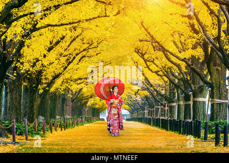 Schöne Mädchen mit traditionellen japanischen kimono in Zeile gelb ginkgo Baum im Herbst. Herbst Park in Tokio, Japan. Stockfoto