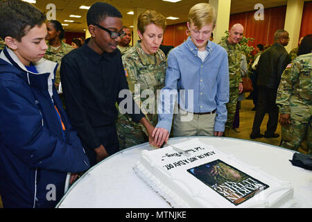 (Von der Mitte links), Herr Anthony Malik Thompson der Vicenza High School, U.S. Army Colonel Christine A. Beeler, Kommandeur der 414 Vertragsparteien Unterstützung Brigade und Herrn Alex Wepper der Vicenza High School, Kuchen, während Martin Luther King, Jr. Day, in Vicenza der militärischen Gemeinschaft 2017 Einhaltung Feier in der Caserma Ederle, Vicenza, Italien, Jan. 10, 2017. (U.S. Armee Foto von visuellen Informationen Spezialist Paolo Bovo/freigegeben) Stockfoto