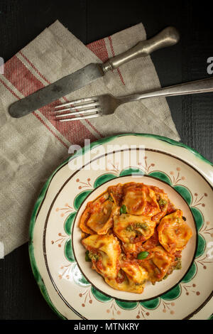 Frische, hausgemachte Tortellini mit Tomatensoße und Mozzarella auf rustikale Platte Stockfoto